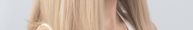 Woman with long blonde hair wearing a white top against a light gray background